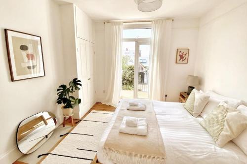 um quarto branco com uma cama grande e uma janela em Juniper House by Walpole Bay - Margate em Kent