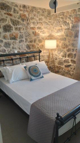 a bed in a room with a stone wall at Fotini's House II in Lygourio