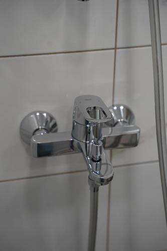 a chrome shower faucet in a bathroom at Sonata apartment in Panevėžys