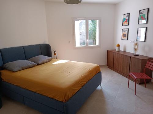 a bedroom with a large bed and a window at Maison de Charme - Maréchalerie - Nîmes in Uchaud