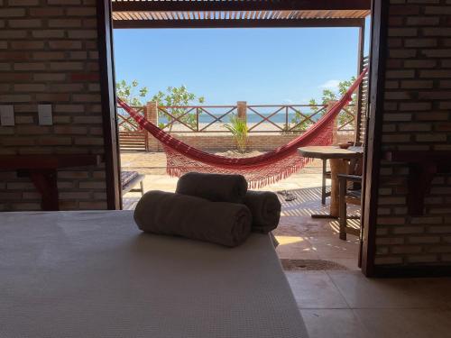 a chair sitting on a bed in front of a sliding glass door at BEACH HOUSE - Loggia Suite 3 - com cozinha - na praia - BEACHFRONT in Barra Grande
