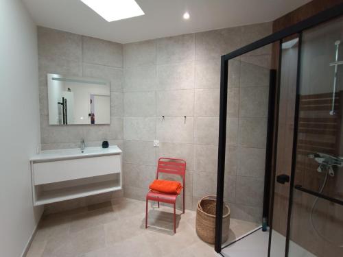 a bathroom with a red chair and a sink at Maison de Charme - Maréchalerie - Nîmes in Uchaud