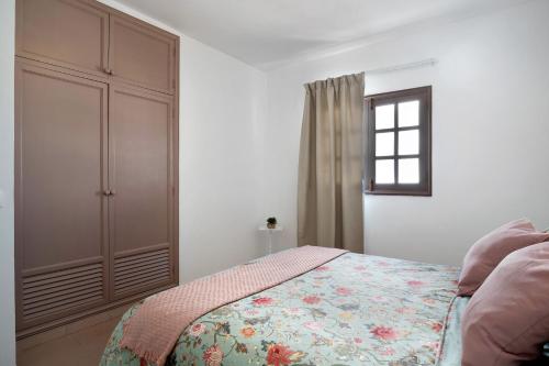a bedroom with a bed and a cabinet and a window at Los Alisios del Patron in Playa Honda