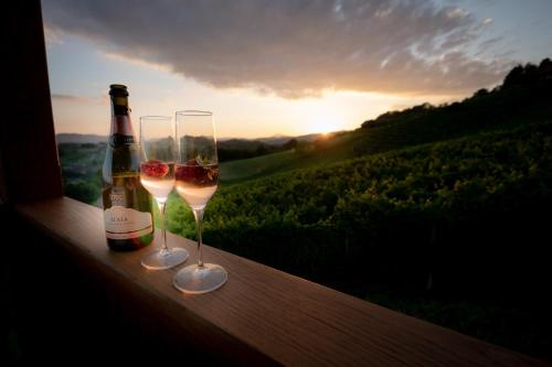 a bottle of wine and two wine glasses on a balcony at Holiday Home Mirt with HotTub & Sauna in Blanca