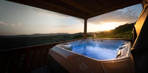 a jacuzzi tub on a balcony with the sunset at Holiday Home Mirt with HotTub & Sauna in Blanca