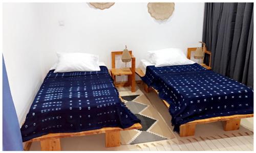 two beds sitting next to each other in a room at Pipi's Guest House in São Filipe