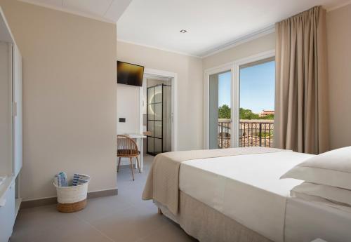 a white bedroom with a bed and a balcony at MEM Lodge and Suite in Pula