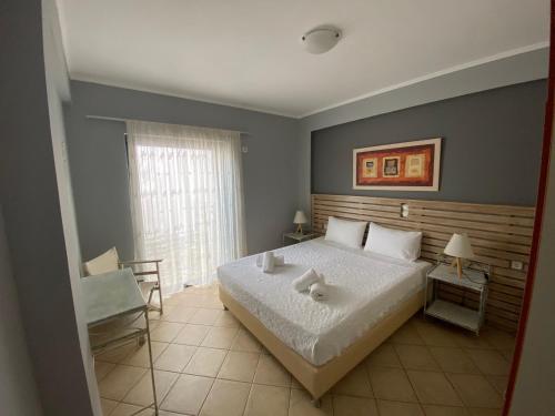 ein Schlafzimmer mit einem großen Bett und einem Fenster in der Unterkunft Sivota Muses in Syvota