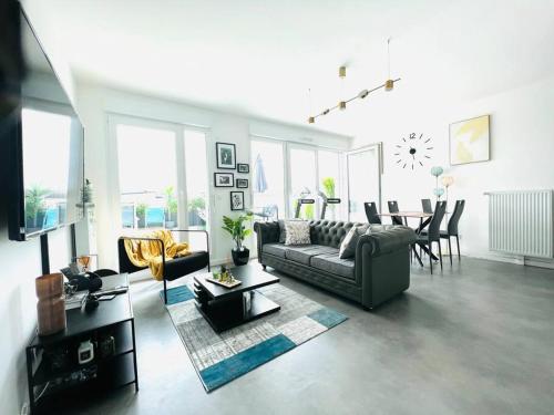 ein Wohnzimmer mit einem Sofa und einem Tisch in der Unterkunft Bel Appartement avec Terrasse privée 86m2 in Noisy-le-Sec