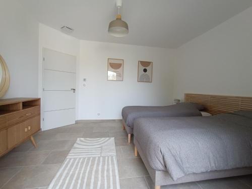 a bedroom with two beds and a rug at Maison de Charme - Maréchalerie - Nîmes in Uchaud