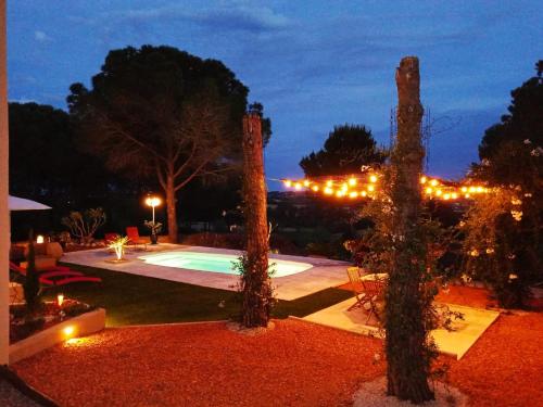 une arrière-cour avec une piscine éclairée la nuit dans l'établissement 