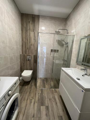 uma casa de banho com um chuveiro, um WC e um lavatório. em VIP апартаменти біля озера em Rivne