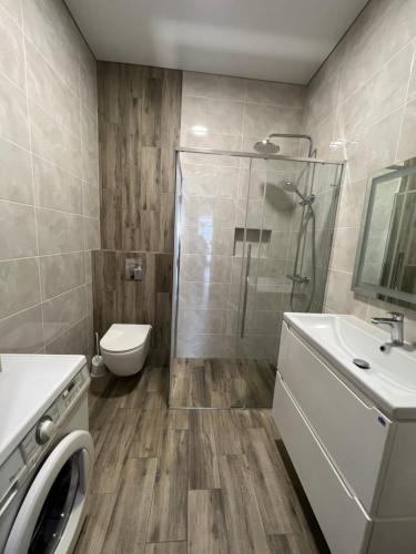 une salle de bain avec une douche, des toilettes et un lavabo dans l'établissement VIP апартаменти біля озера, à Rivne