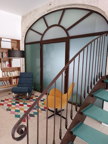 a living room with a staircase and a chair at Maison de Charme - Maréchalerie - Nîmes in Uchaud