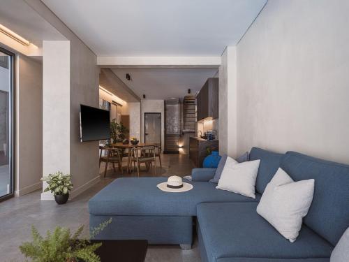 a living room with a blue couch and a table at Grand Residences in Chania Town