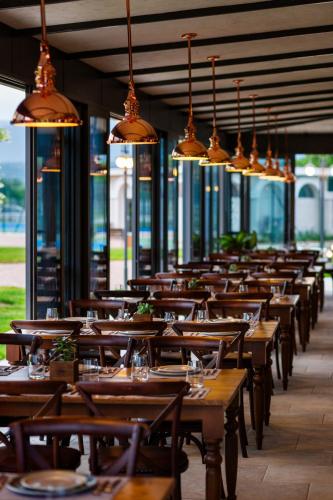 an empty restaurant with wooden tables and lights at Kings' Valley Medical & Spa Hotel in Kazanlŭk
