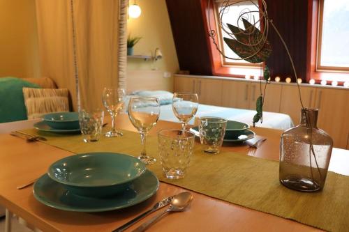 a wooden table with plates and glasses on it at Apartma Luka, Bovec in Bovec