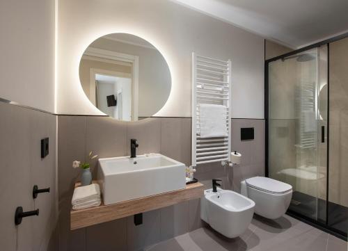 a bathroom with a sink and a toilet and a mirror at MEM Lodge and Suite in Pula