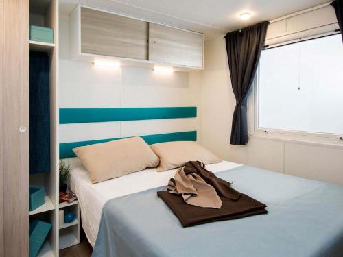 バイア・ドミツィアにあるDetached chalet with AC, in a natural park on the coastのベッド2台と窓が備わる小さな客室です。