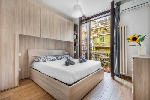 a bedroom with a bed and a large window at Divi Apartments Milano - Strategic Place in Milan