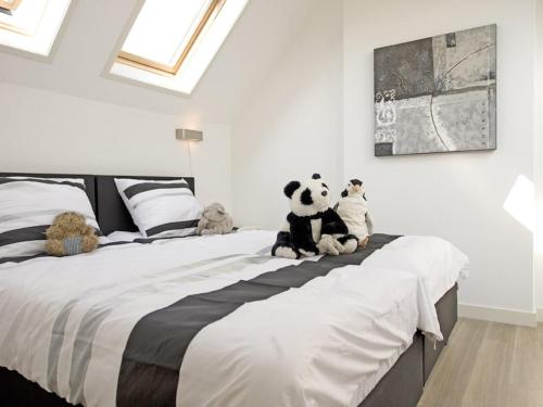 Un dormitorio con una cama grande con animales de peluche. en Modern design lodge on the water located on a holiday park in a national park, en Tholen