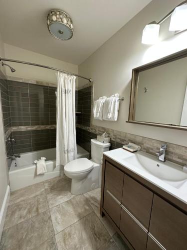 a bathroom with a toilet and a tub and a sink at Elaine's Cape May Boutique Hotel in Cape May