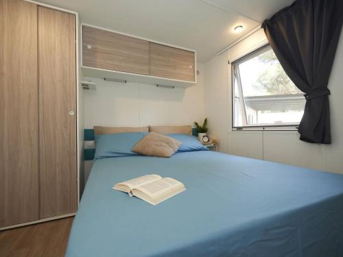 um quarto com uma grande cama azul e uma janela em Detached chalet with AC, in a natural park on the coast em Baia Domizia