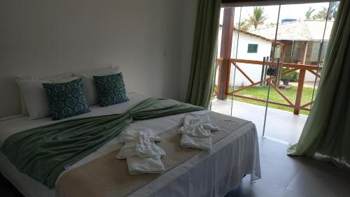 a bedroom with a bed with towels on it at POUSADA ACONCHEGO CHAPADA in Alto Paraíso de Goiás