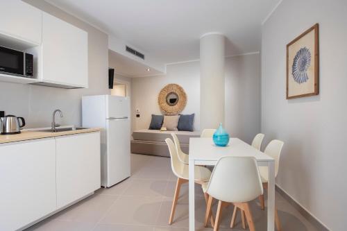 a kitchen and dining room with a white table and chairs at MEM Lodge and Suite in Pula