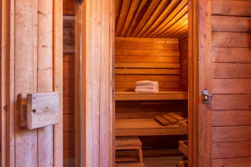 a wooden sauna with a wooden door in a room at Domaine du Limonay, The Originals Collection in Saint-Méloir-des-Ondes