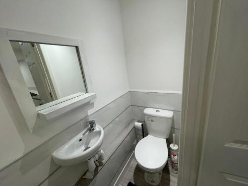 a bathroom with a toilet and a sink and a mirror at Guest Room-Studio, Woolwich in Woolwich