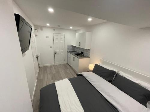 a bedroom with a black and white bed and a kitchen at Guest Room-Studio, Woolwich in Woolwich