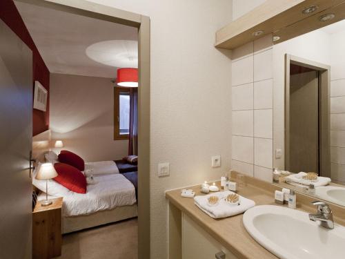 a bathroom with a sink and a bedroom with a bed at Modern apartment near the ski lift in an authentic village in Sainte-Foy-Tarentaise