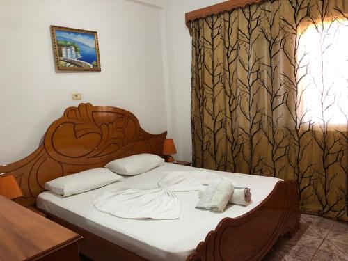 - une chambre avec un lit en bois et des serviettes dans l'établissement Arsen Apartments, à Saranda