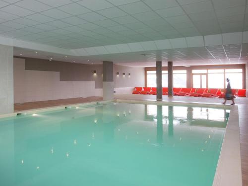 - une piscine d'eau bleue dans une chambre avec des chaises rouges dans l'établissement Chalet in Alps near Ski Slopes, à Sainte-Foy-Tarentaise