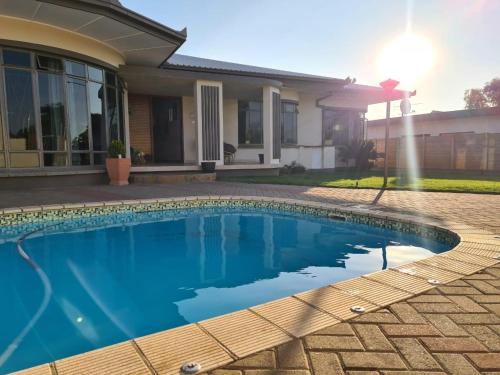 a swimming pool in front of a house at Meerkat Manor Self-Catering & Accommodation Windhoek in Windhoek