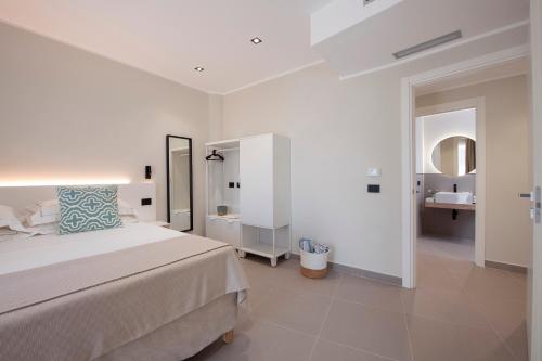 a white bedroom with a bed and a bathroom at MEM Lodge and Suite in Pula