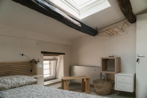 sypialnia z łóżkiem, stołem i oknem dachowym w obiekcie Abbergà w mieście Santa Fiora