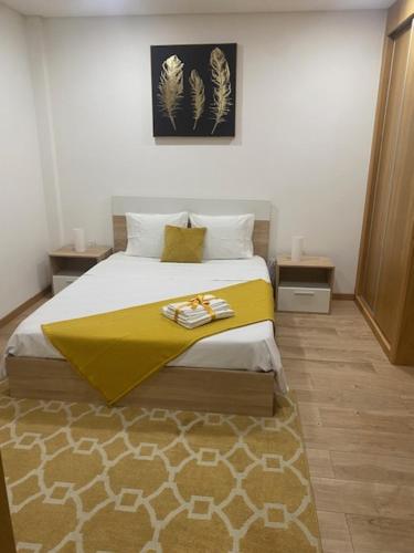 um quarto com uma cama com um cobertor amarelo em IPB Studios em Bragança