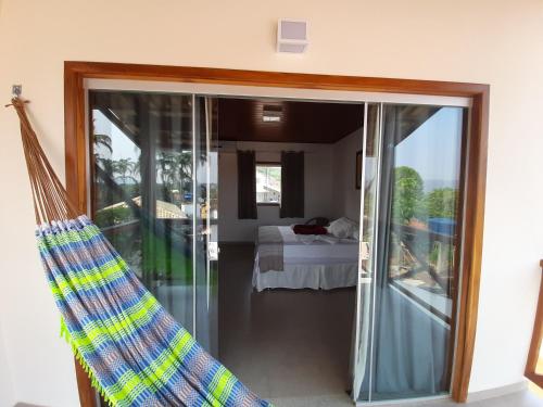 Habitación con una puerta de cristal que conduce a un dormitorio. en POUSADA ACONCHEGO CHAPADA, en Alto Paraíso de Goiás