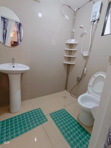 uma casa de banho com um lavatório, um WC e um chuveiro em San Pablo laguna staycation em San Pablo