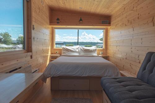 a bedroom with a bed and a large window at Hutton Brickyards Riverfront Hotel & Venue in Kingston