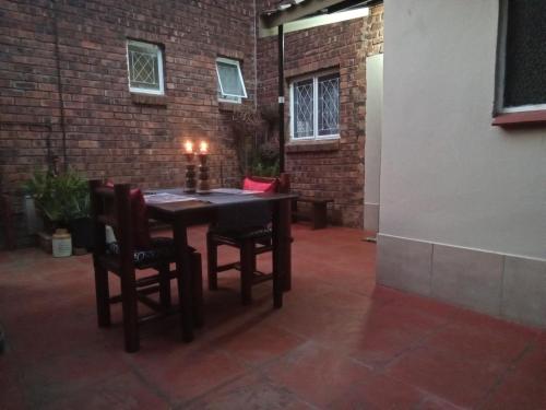 a table and chairs in a room with a brick wall at Howick Greendale 4 Self Catering Units Solar & Battery Back-Up in Howick