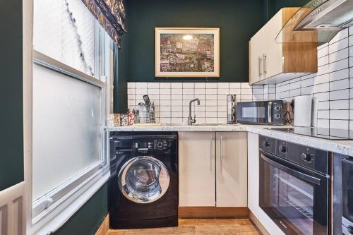 a kitchen with a washing machine in a dishwasher at The Snug @ Clarence in Derry Londonderry
