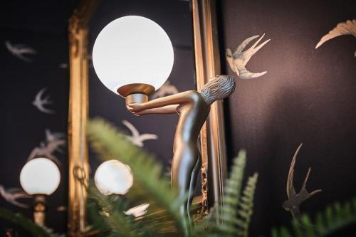 a statue of a person holding a light in front of a mirror at The Snug @ Clarence in Derry Londonderry