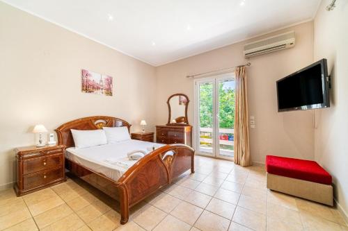 a bedroom with a bed and a flat screen tv at Giourgas house in Chlomatianá