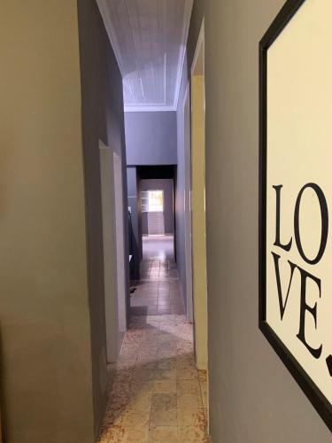 a hallway with a long room with a sign on the wall at Stay Residence - HOSTEL - CASA COMPARTILHADA in Recife
