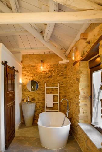 a bathroom with a large tub and a sink at Casa ENTREPIEDRAS in Villalís