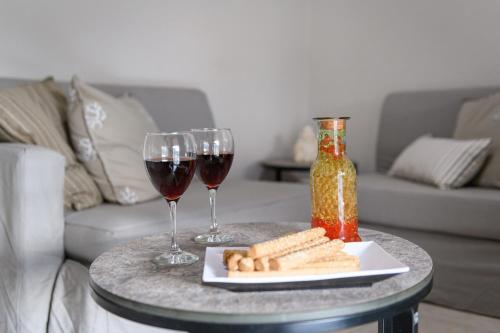 a table with two glasses of wine and a plate of food at Notus Vacation House in Lefkímmi