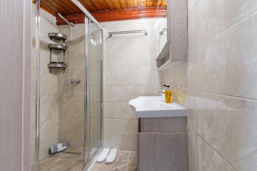 a bathroom with a shower and a sink at Notus Vacation House in Lefkimmi